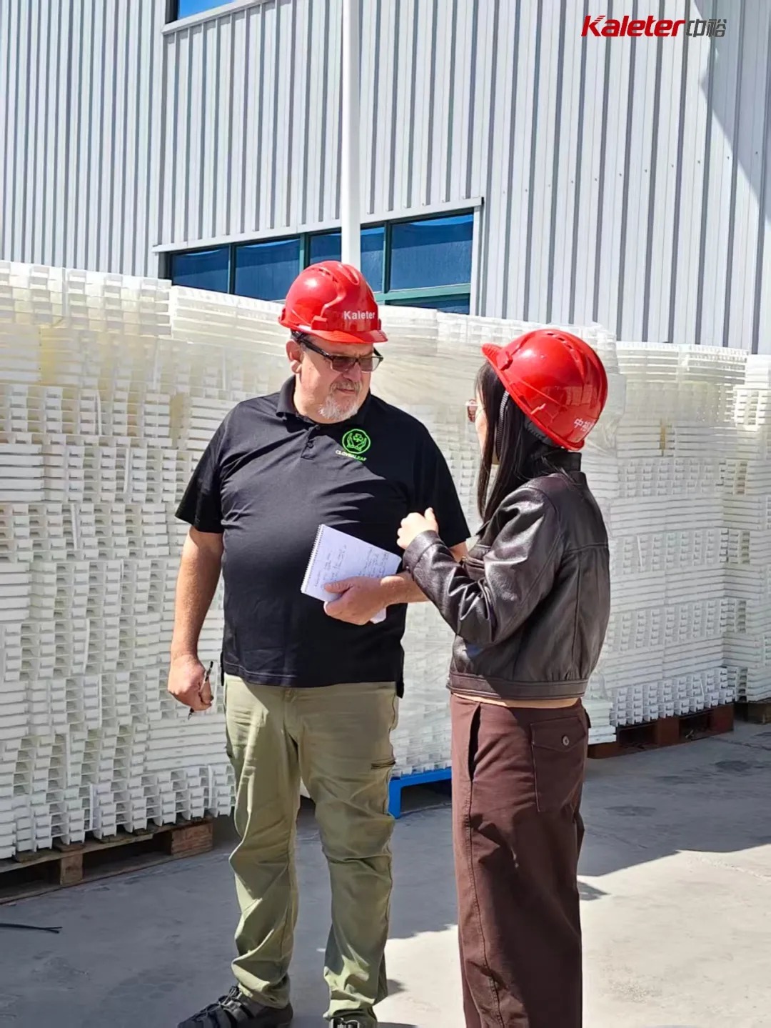 CloverLeaf auditor and Kaleter staff reviewing stacked equipment components outside the facility